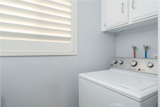 clothes washing area with cabinets and washer / clothes dryer