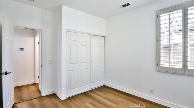 unfurnished bedroom with hardwood / wood-style floors and a closet