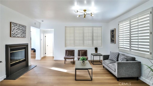 living room featuring light wood-type flooring and an inviting chandelier