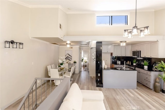 kitchen featuring white cabinetry, stainless steel appliances, backsplash, pendant lighting, and sink