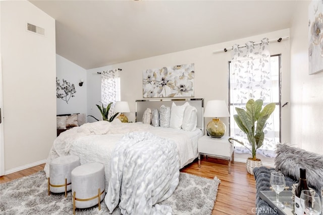 bedroom with vaulted ceiling and hardwood / wood-style floors