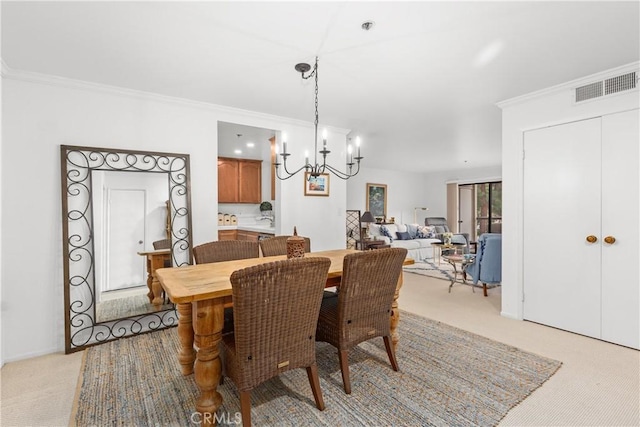 carpeted dining area with crown molding and a chandelier