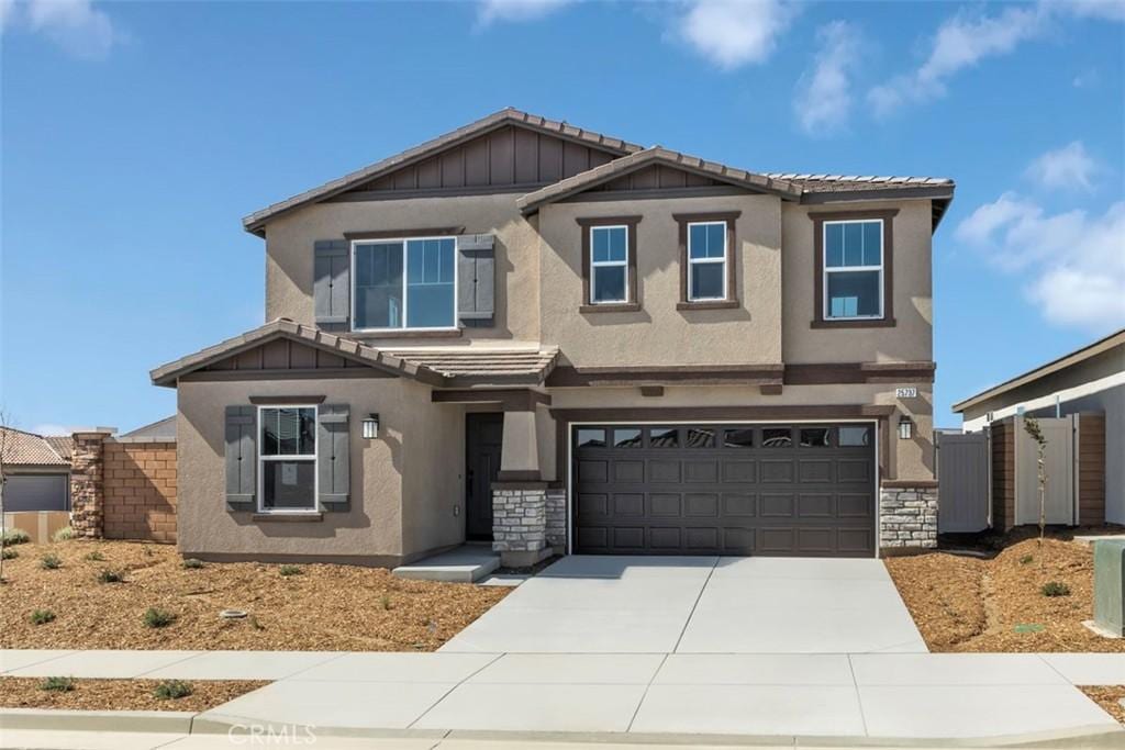 craftsman-style house with driveway, fence, and stucco siding