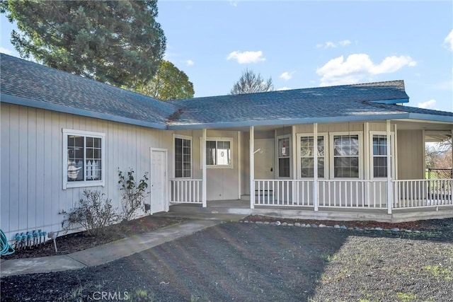 property entrance with a porch and a shingled roof