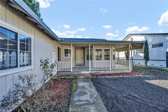 view of exterior entry featuring covered porch