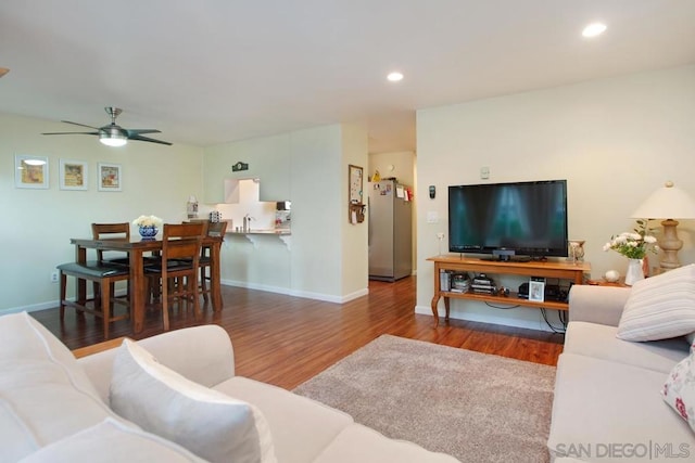 living room featuring ceiling fan and dark hardwood / wood-style flooring