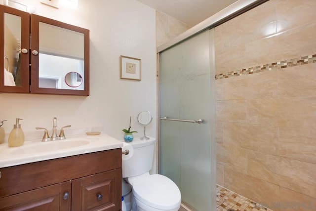 bathroom featuring vanity, toilet, and walk in shower