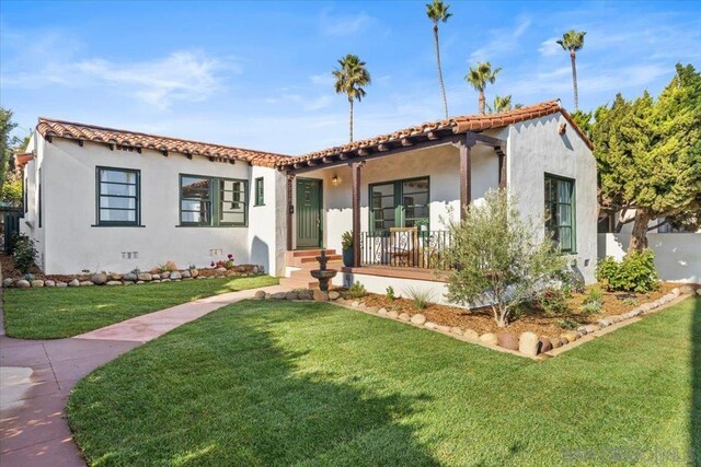 mediterranean / spanish house featuring a porch and a front lawn