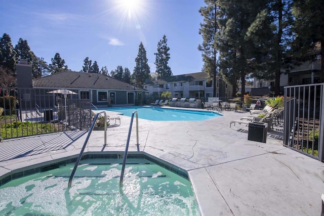 view of swimming pool featuring a patio area and a community hot tub