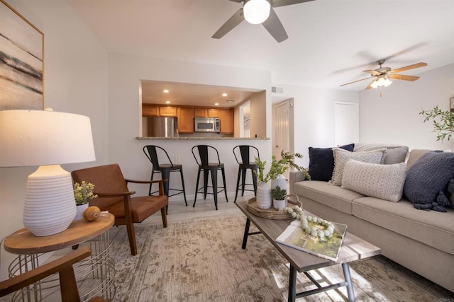 living room with ceiling fan and light hardwood / wood-style floors