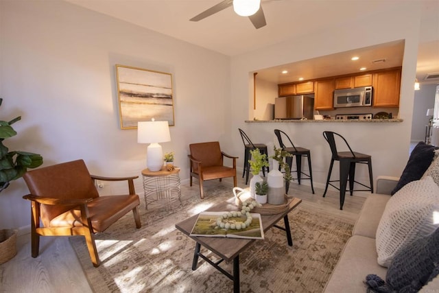 living room featuring ceiling fan and light hardwood / wood-style flooring