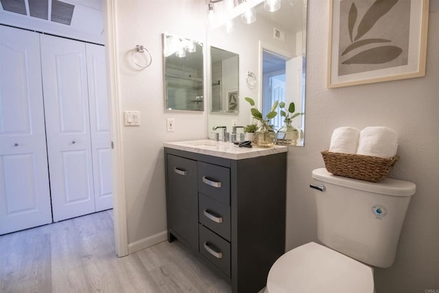 bathroom with vanity, hardwood / wood-style floors, and toilet