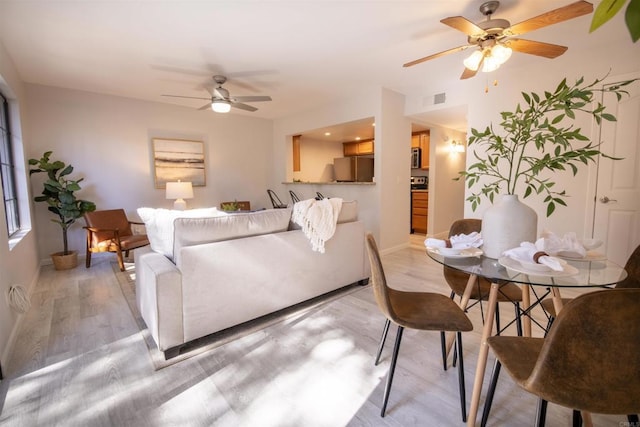 living room with ceiling fan and light wood-type flooring