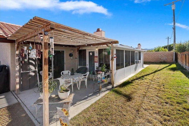 rear view of property with a pergola, a patio area, a sunroom, and a yard