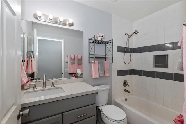 full bathroom featuring toilet, vanity, and tiled shower / bath