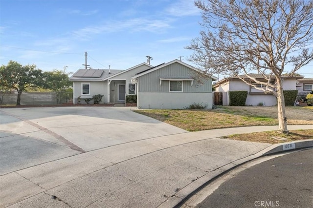 single story home featuring a front yard and solar panels