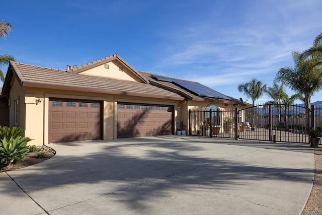 view of front facade featuring solar panels and a garage