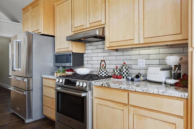 kitchen with backsplash, high end appliances, light stone countertops, light brown cabinetry, and dark hardwood / wood-style flooring