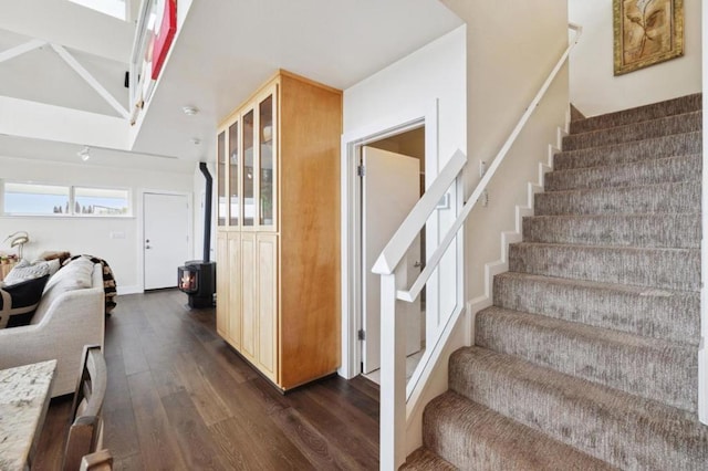 stairs with hardwood / wood-style flooring, a wood stove, and plenty of natural light