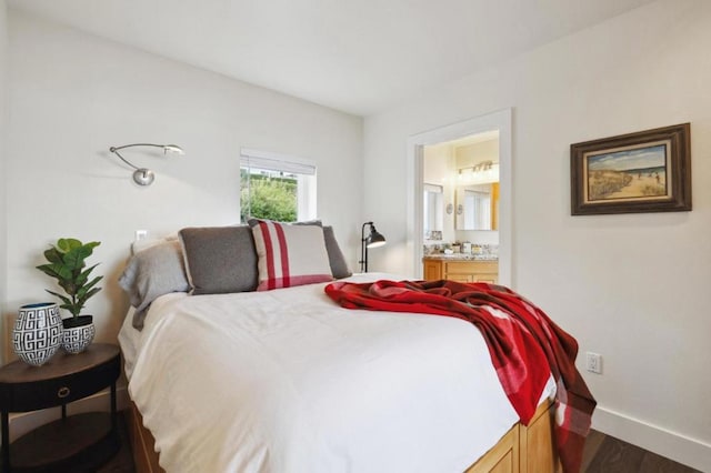 bedroom with ensuite bathroom and dark hardwood / wood-style flooring