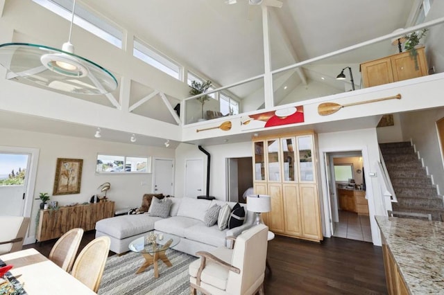 living room with high vaulted ceiling, dark hardwood / wood-style floors, and beam ceiling