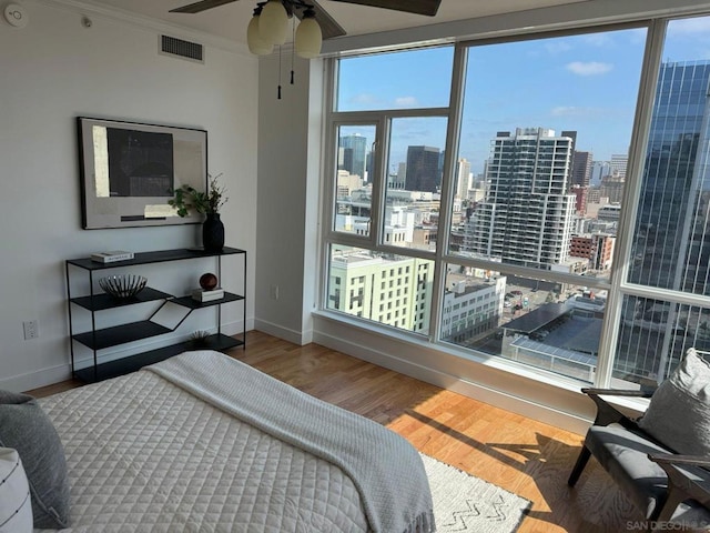 bedroom featuring ceiling fan, ornamental molding, and hardwood / wood-style flooring