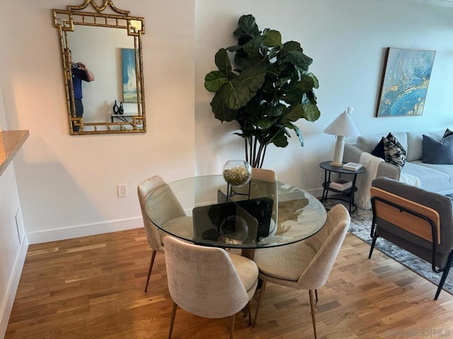 dining space with wood-type flooring