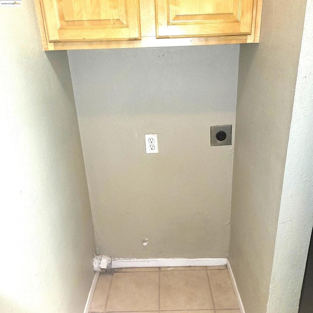 clothes washing area with cabinets, light tile patterned floors, and hookup for an electric dryer