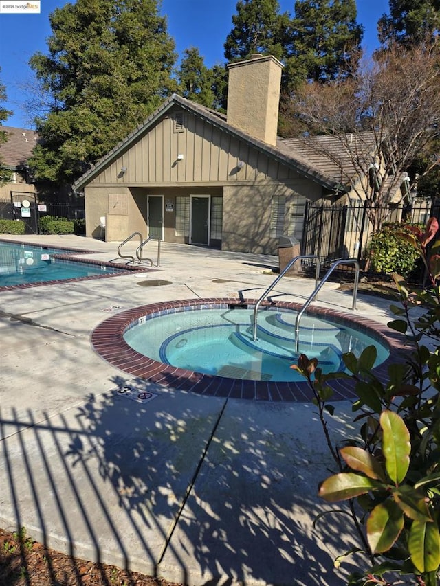 view of swimming pool featuring a patio and a community hot tub