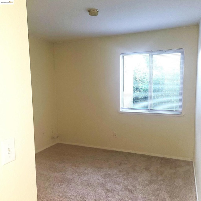 unfurnished room featuring light carpet