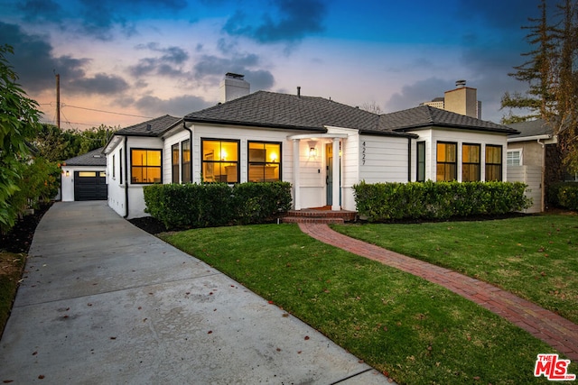 view of front of house featuring a garage and a lawn