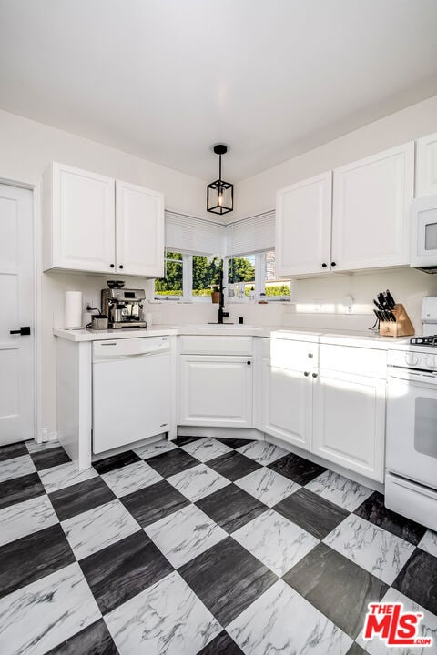 kitchen with hanging light fixtures, white cabinets, sink, and white appliances