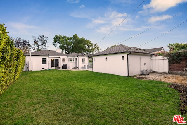 rear view of house with a lawn and central air condition unit