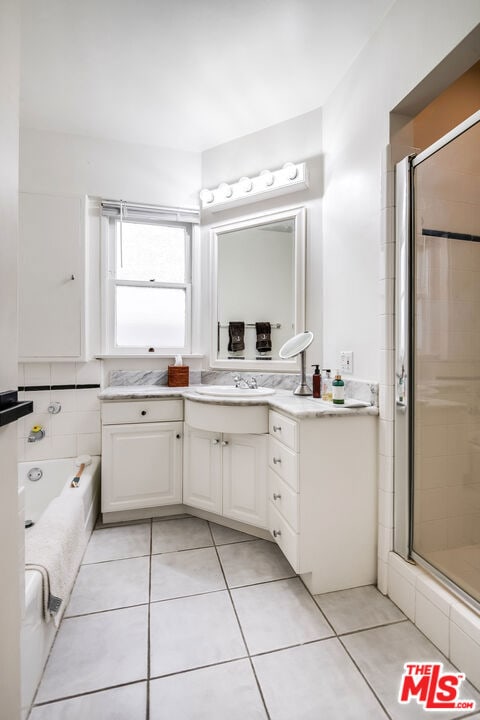 bathroom featuring tile patterned floors, vanity, and shower with separate bathtub