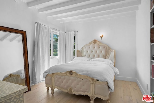 bedroom featuring beam ceiling and light hardwood / wood-style flooring