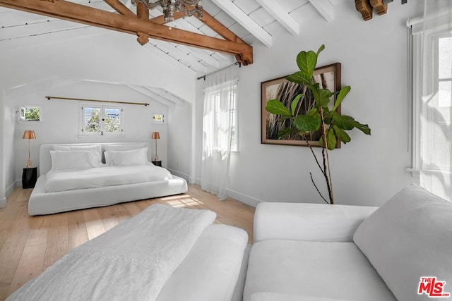 bedroom featuring light hardwood / wood-style flooring, vaulted ceiling with beams, and multiple windows