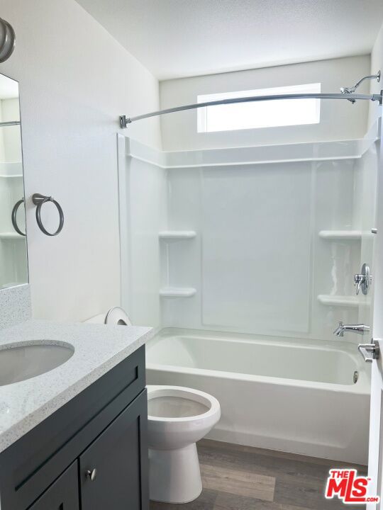 full bathroom featuring vanity, bathing tub / shower combination, plenty of natural light, and hardwood / wood-style floors