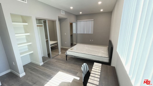 bedroom with a closet and hardwood / wood-style floors