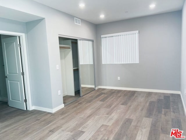 unfurnished bedroom featuring a closet and light hardwood / wood-style flooring