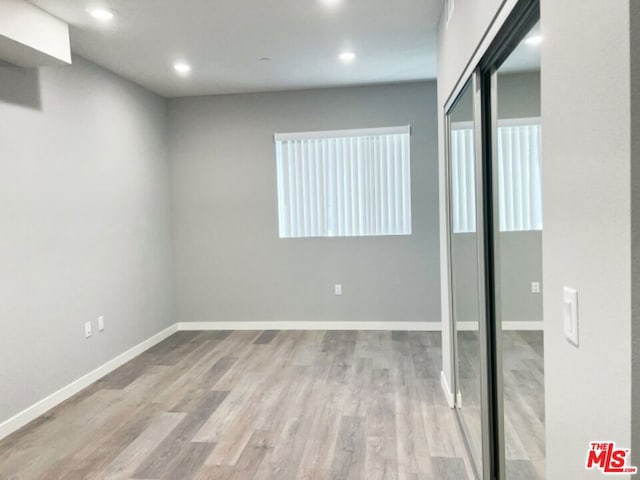 basement with light hardwood / wood-style flooring