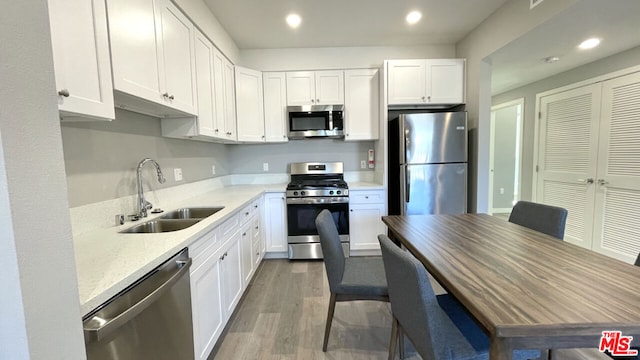 kitchen featuring appliances with stainless steel finishes, white cabinetry, and sink