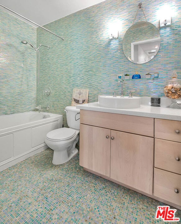 full bathroom featuring tile patterned floors, vanity, toilet, and tiled shower / bath