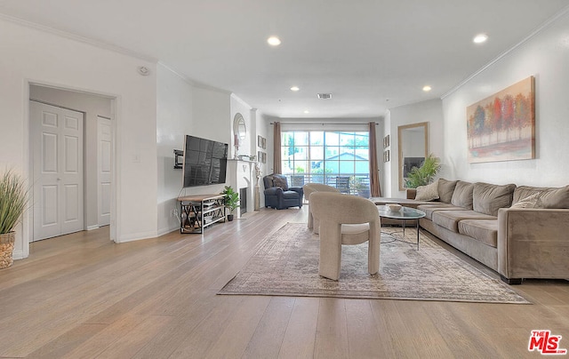 living room featuring light wood-type flooring and crown molding