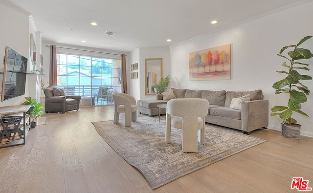 living room featuring ornamental molding and light hardwood / wood-style flooring