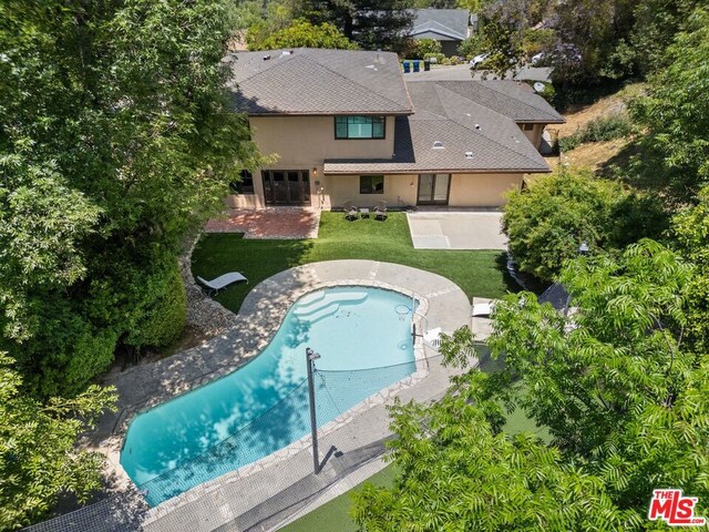 view of pool with a lawn and a patio area