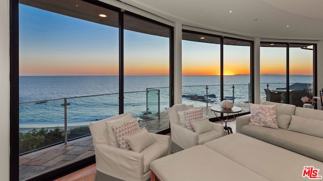 sunroom featuring a wealth of natural light and a water view