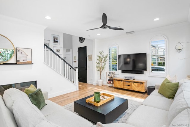 living room featuring ceiling fan, ornamental molding, and hardwood / wood-style flooring