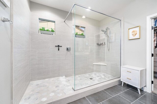 bathroom with tile patterned floors and tiled shower