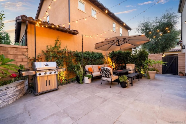 patio terrace at dusk with an outdoor hangout area and area for grilling