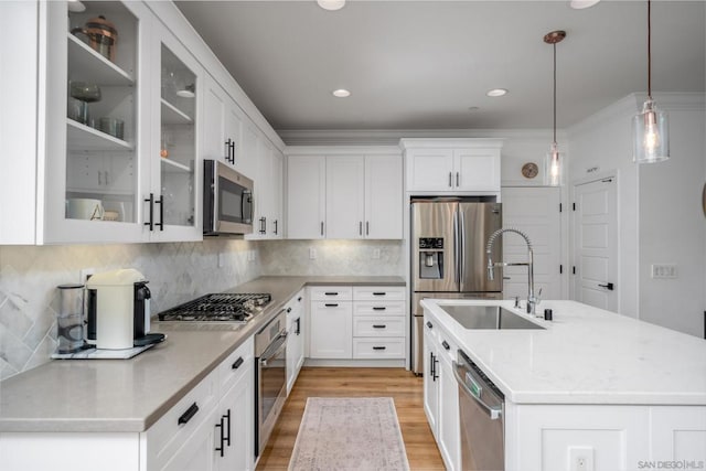 kitchen with decorative light fixtures, appliances with stainless steel finishes, sink, and white cabinetry